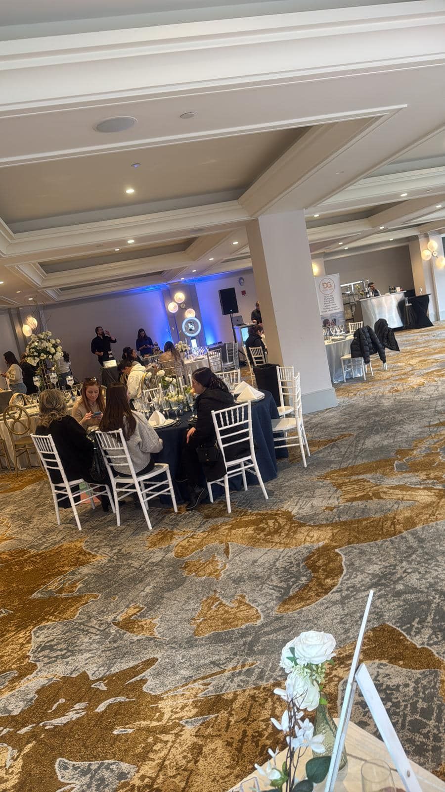 A group of people are sitting at tables in a large room.