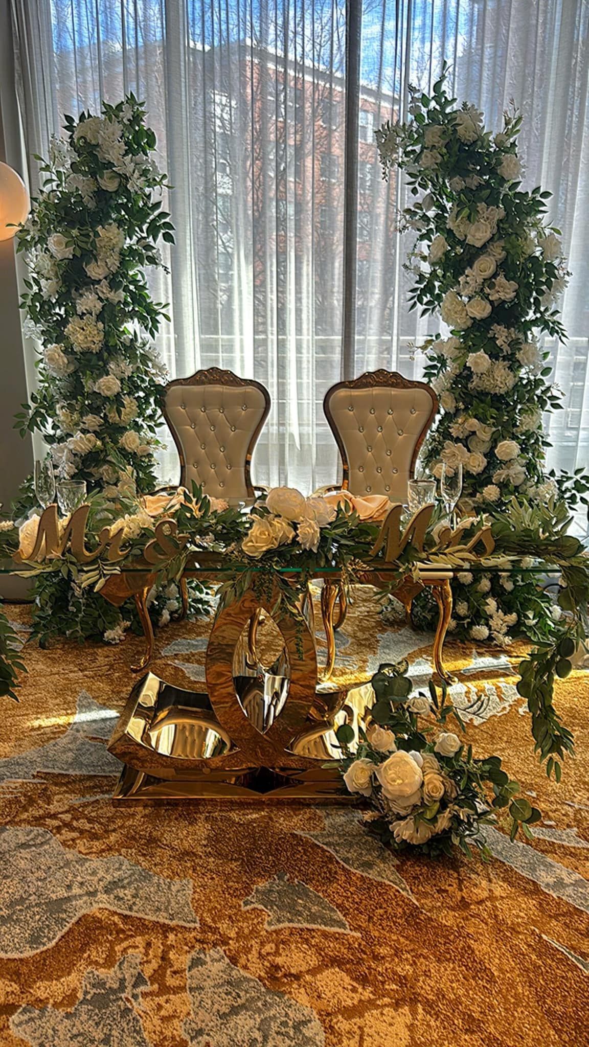 A couple of chairs sitting at a table with flowers on it.