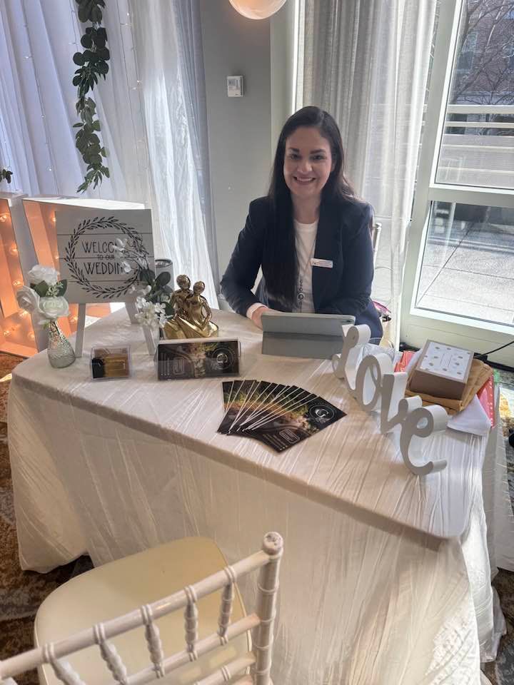A woman is sitting at a table with a tablet.