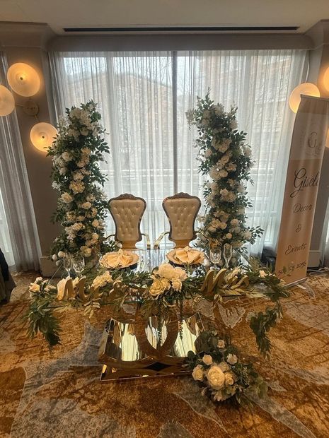 A couple of chairs sitting at a table with flowers on it.