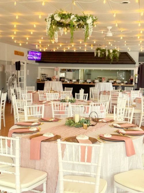 A table with a cake , cookies , and flowers on it.