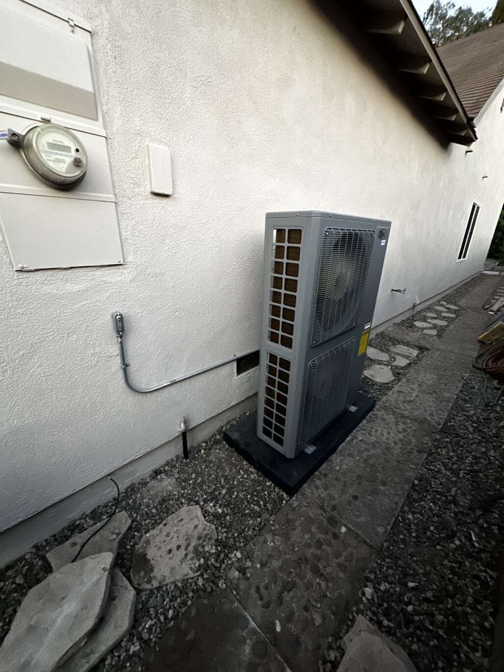 A large air conditioner is sitting on the side of a building.
