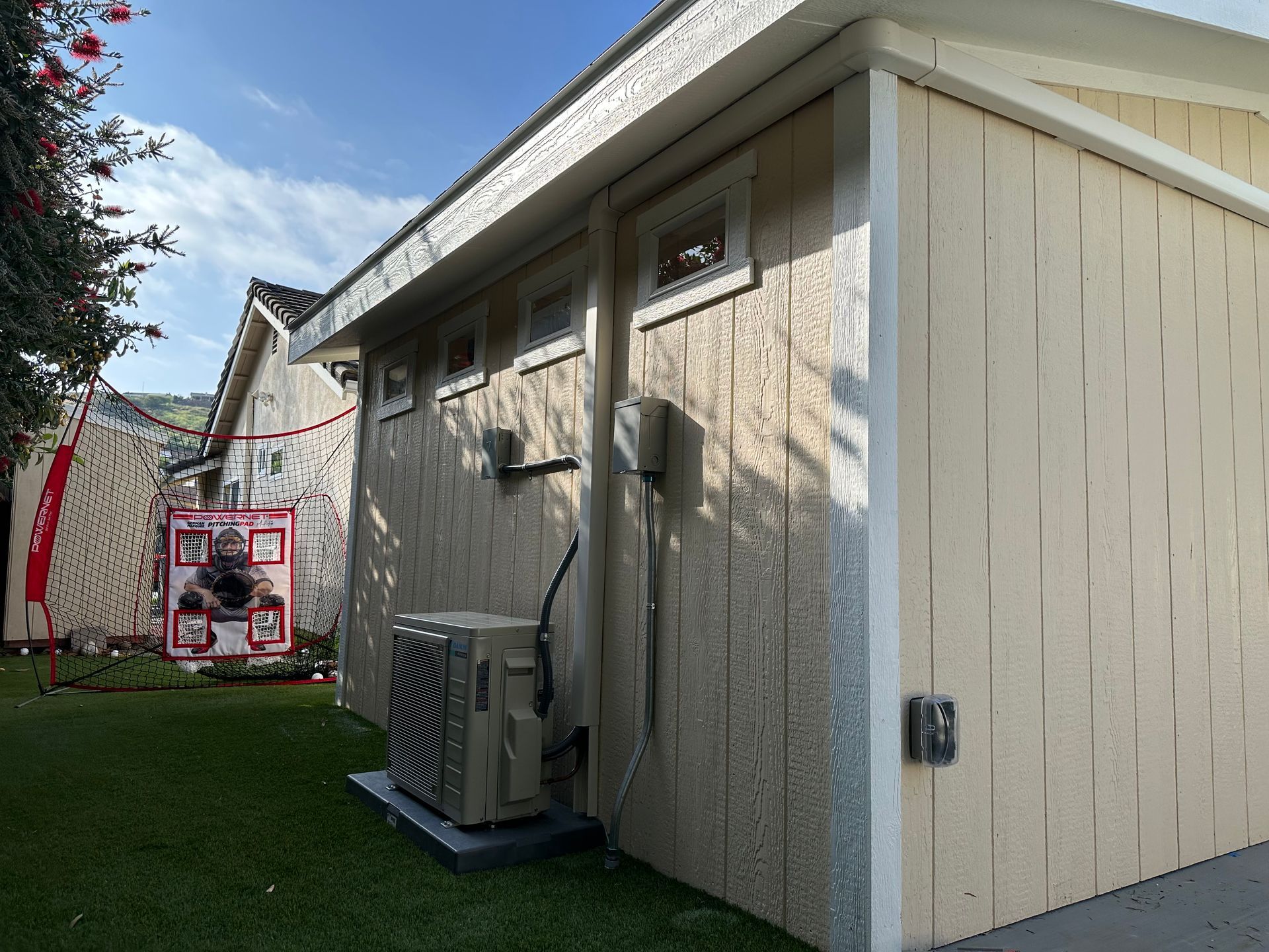 A shed with a large air conditioner on the side of it.