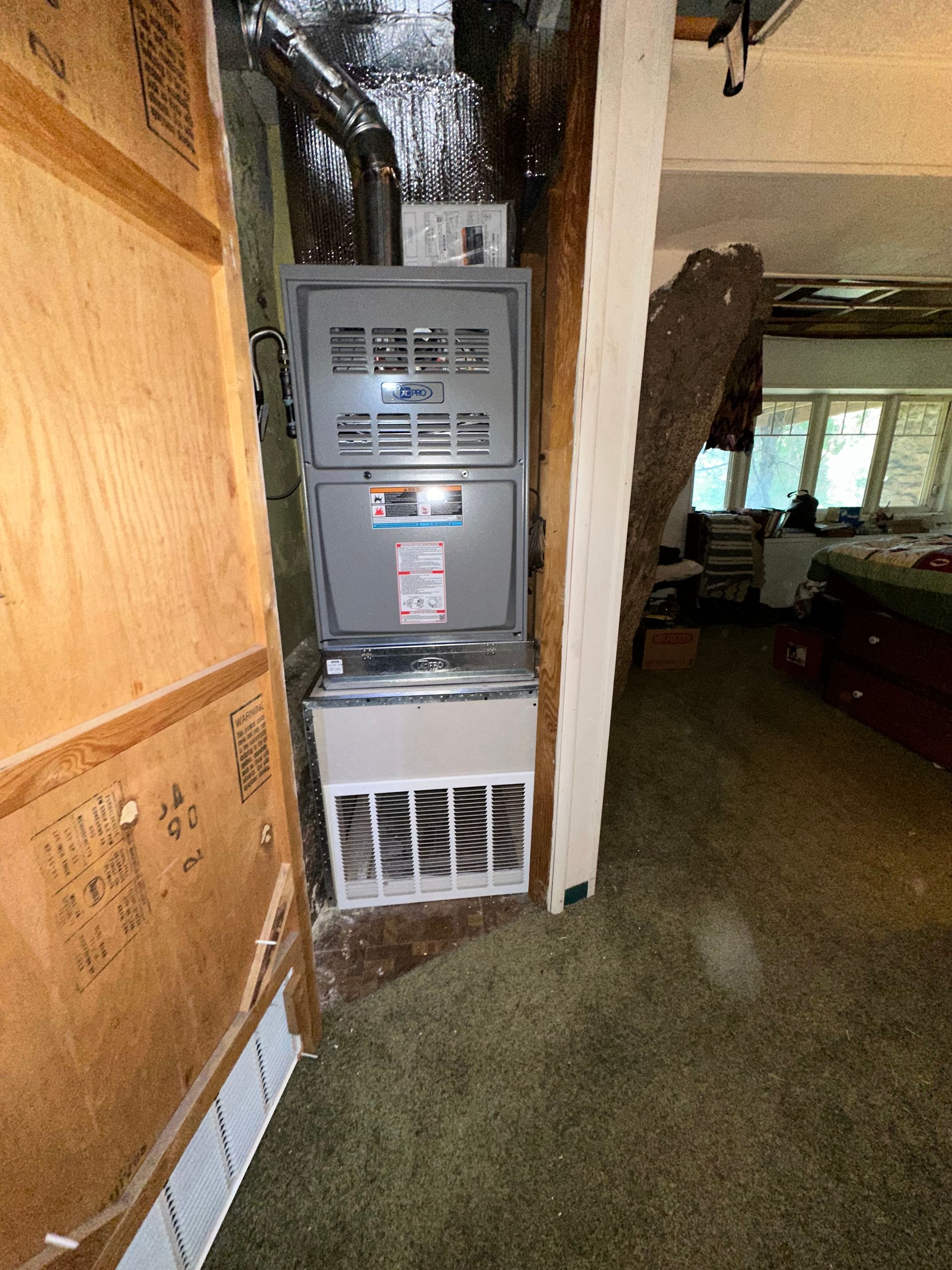An air conditioner is sitting in the corner of a room in a house.