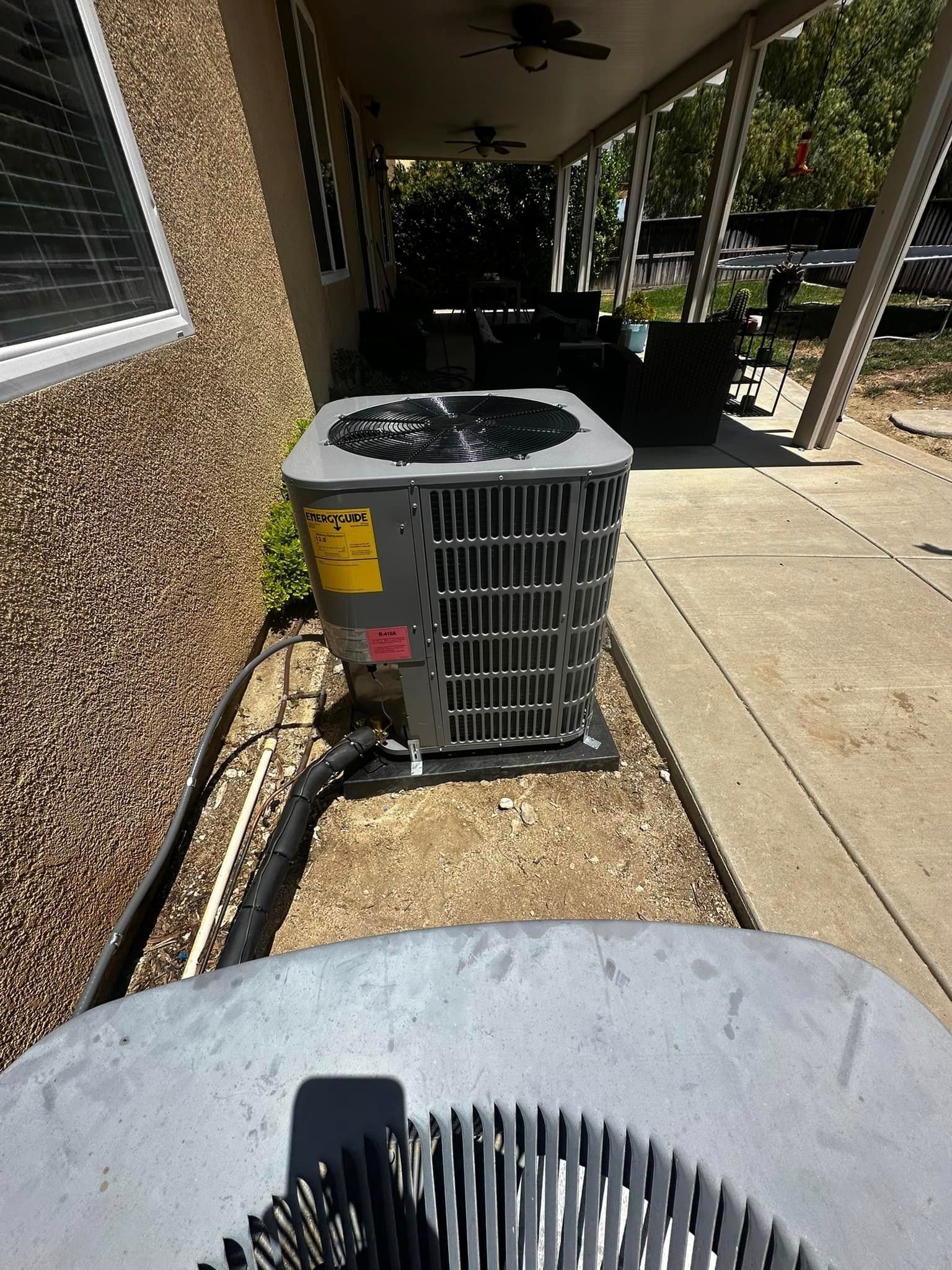 An air conditioner is sitting on the side of a house.