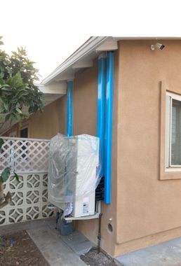 A house with a blue pipe on the side of it.