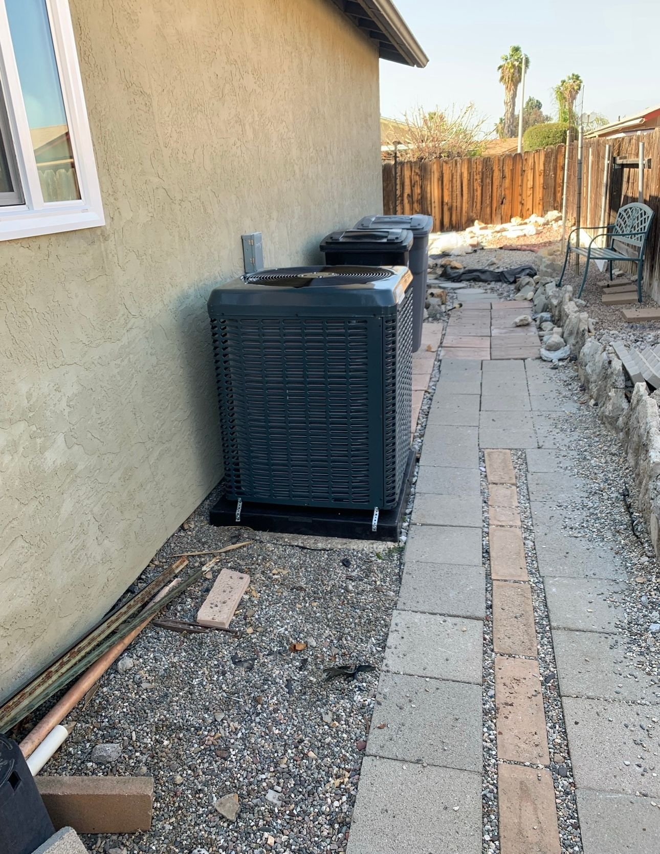 An air conditioner is sitting on the side of a house.