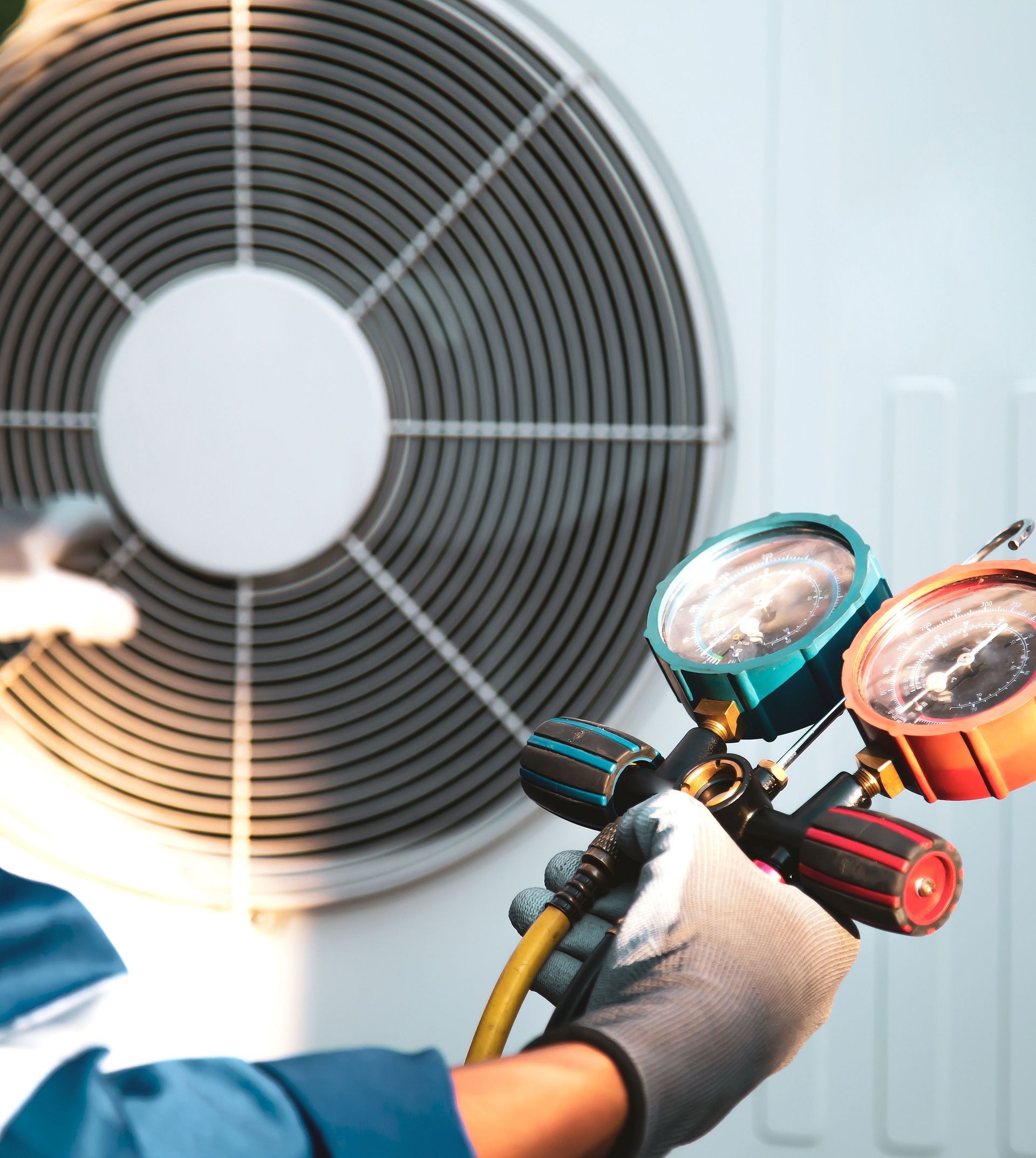 A man is holding a gauge in front of an air conditioner
