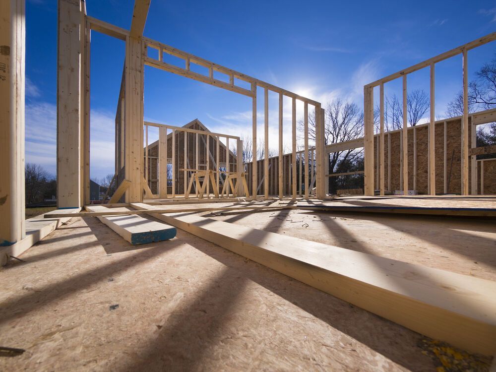 House Being Built With Wooden Beams And A Blue Sky — R3 Construction In Queanbeyan, NSW