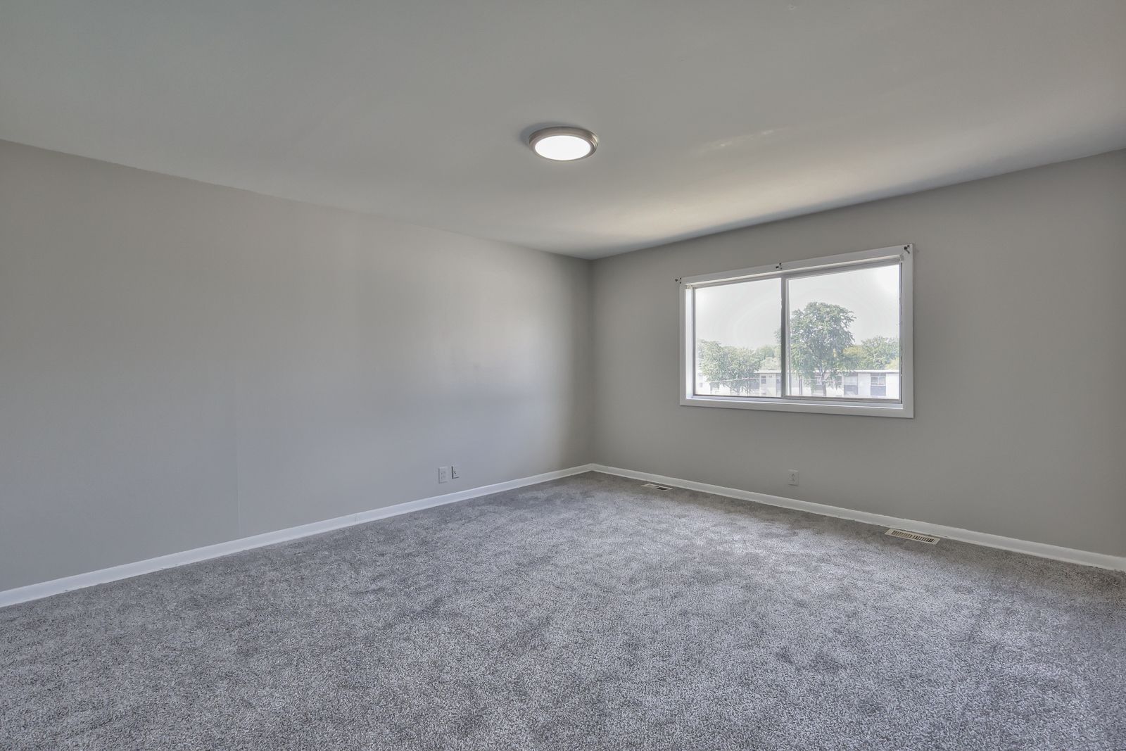 Photo of a large, carpeted bedroom