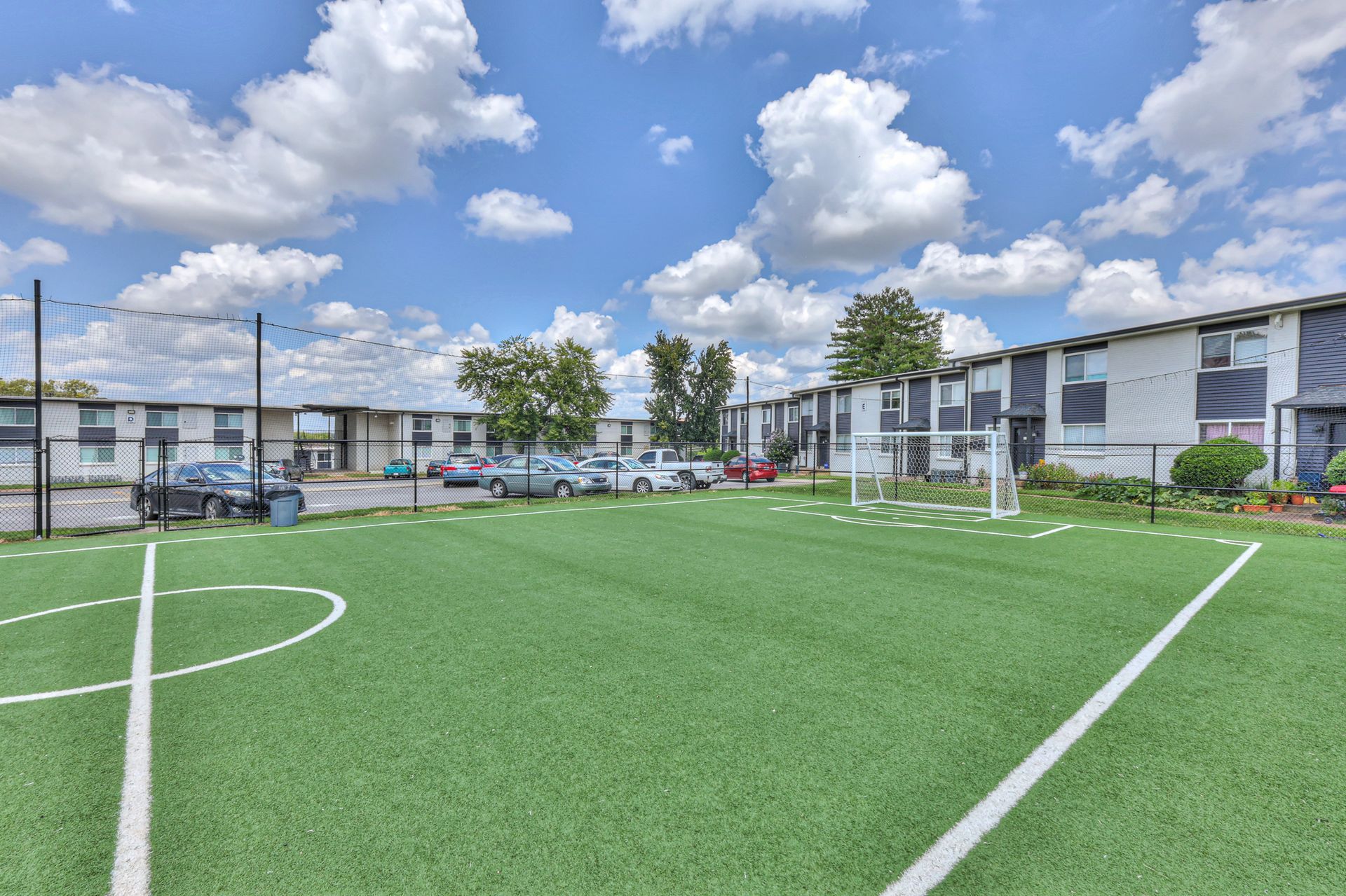 Photo of a community soccer field, with buildings in the background