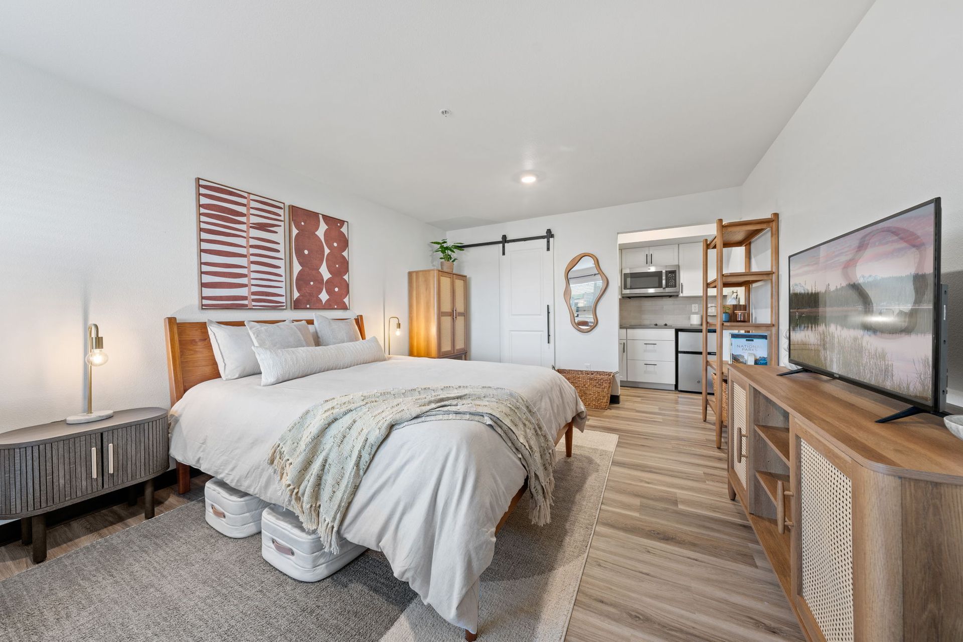 A bedroom with a large bed and a flat screen tv.