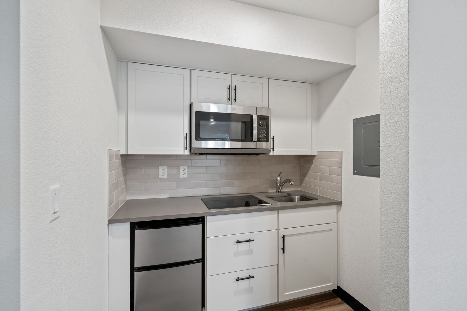 A small kitchen with stainless steel appliances and white cabinets.