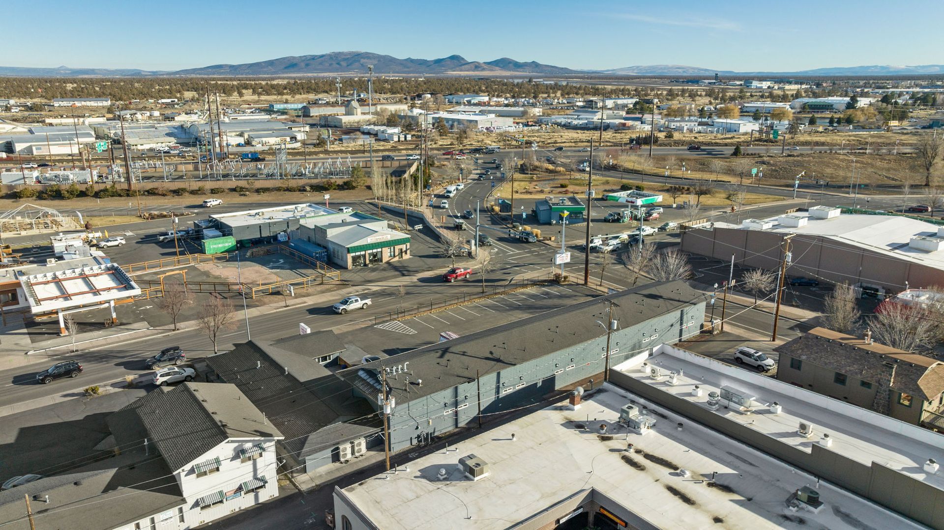 An aerial view of a city with a lot of buildings and mountains in the background.
