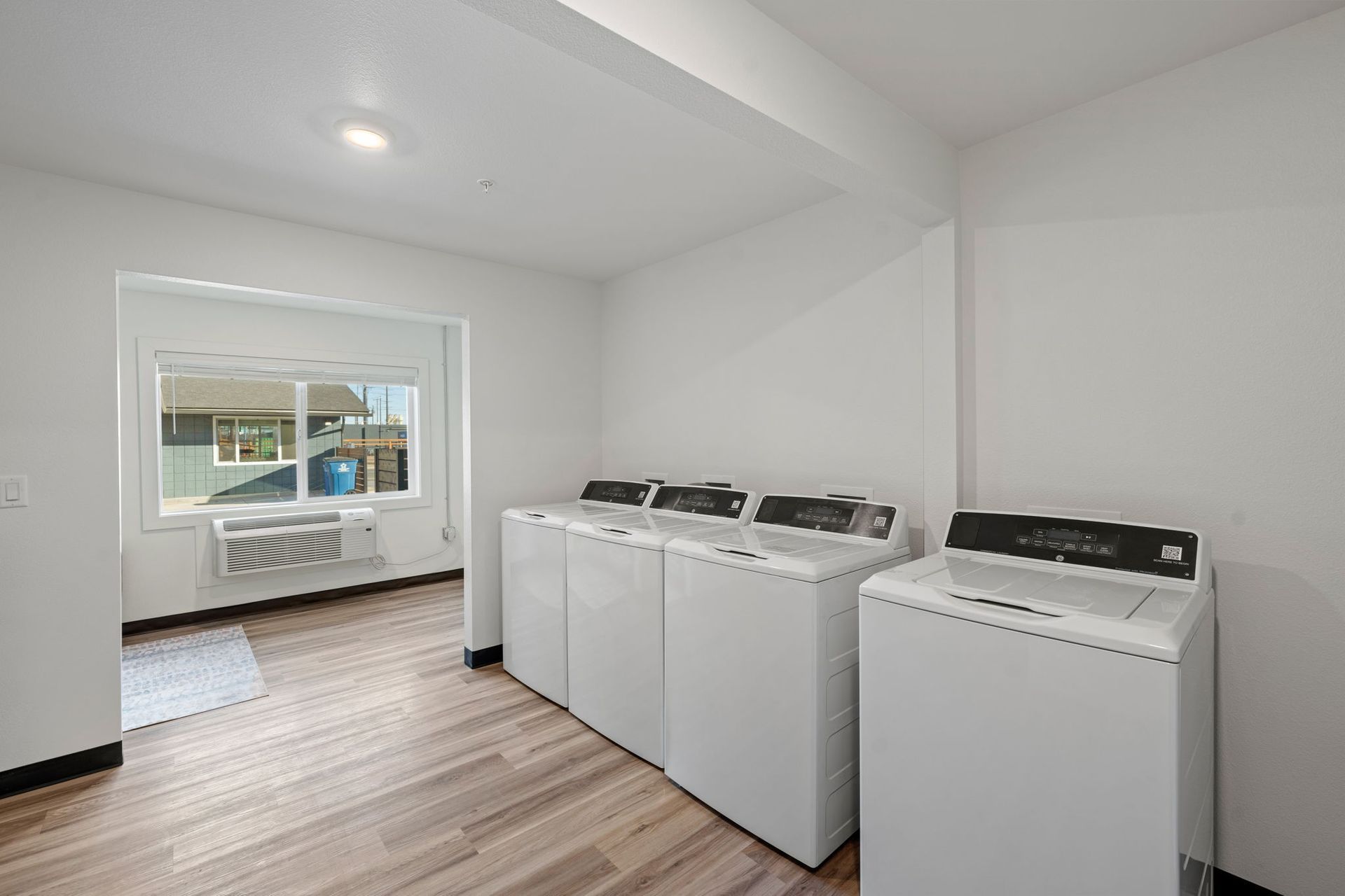 A laundry room with two washing machines and a window.