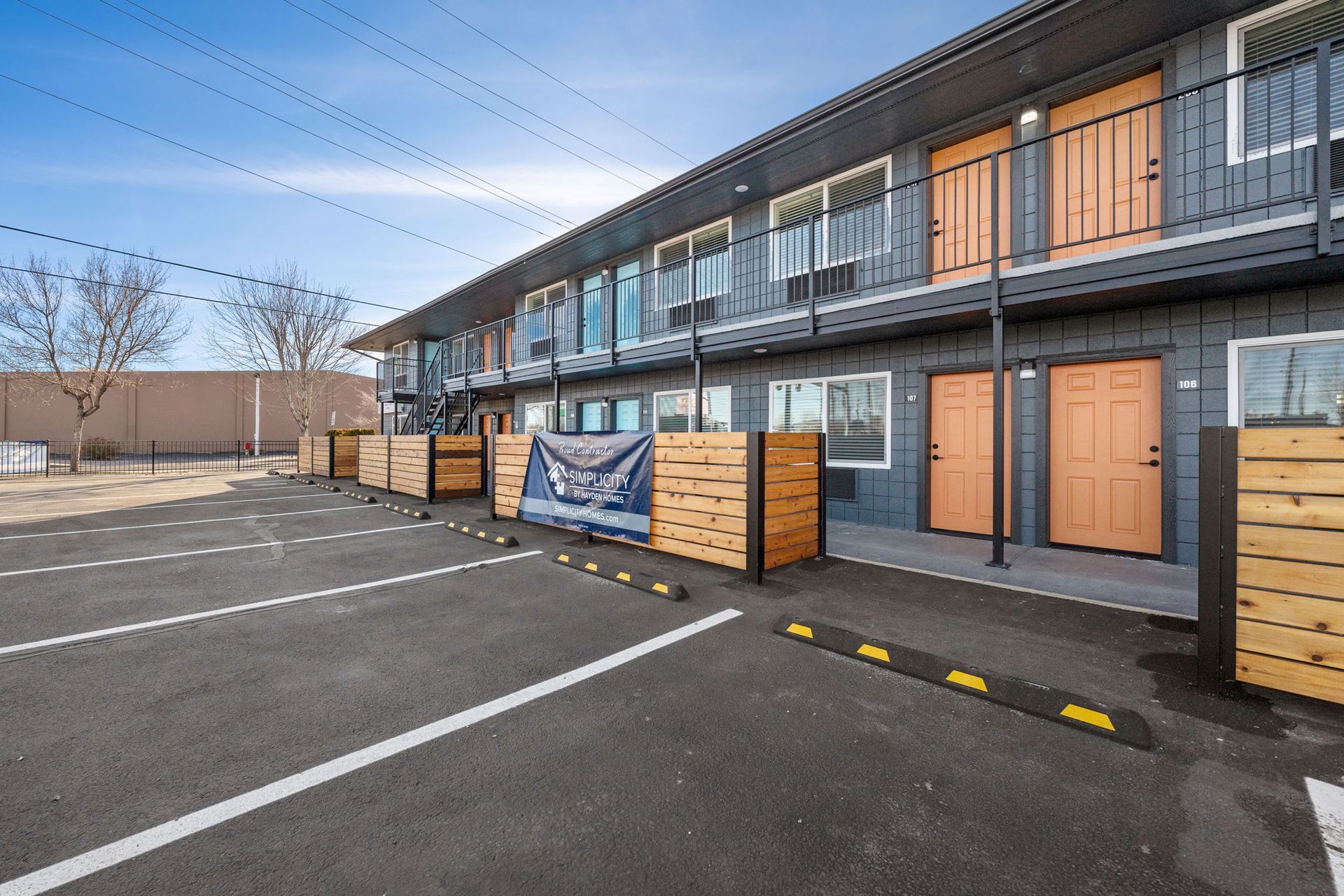 A large apartment building with a parking lot in front of it.