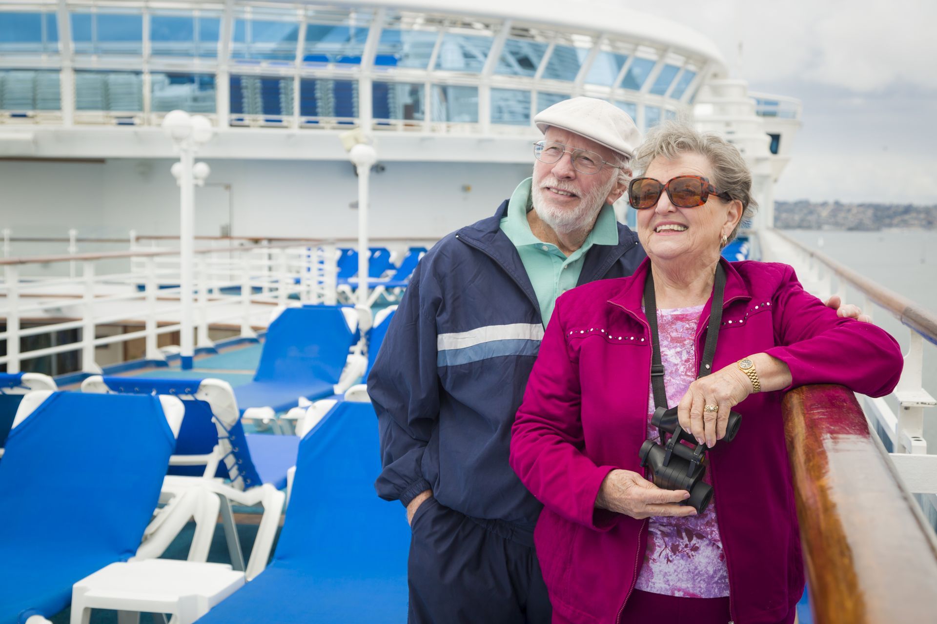 A man and a woman are standing on a cruise ship.