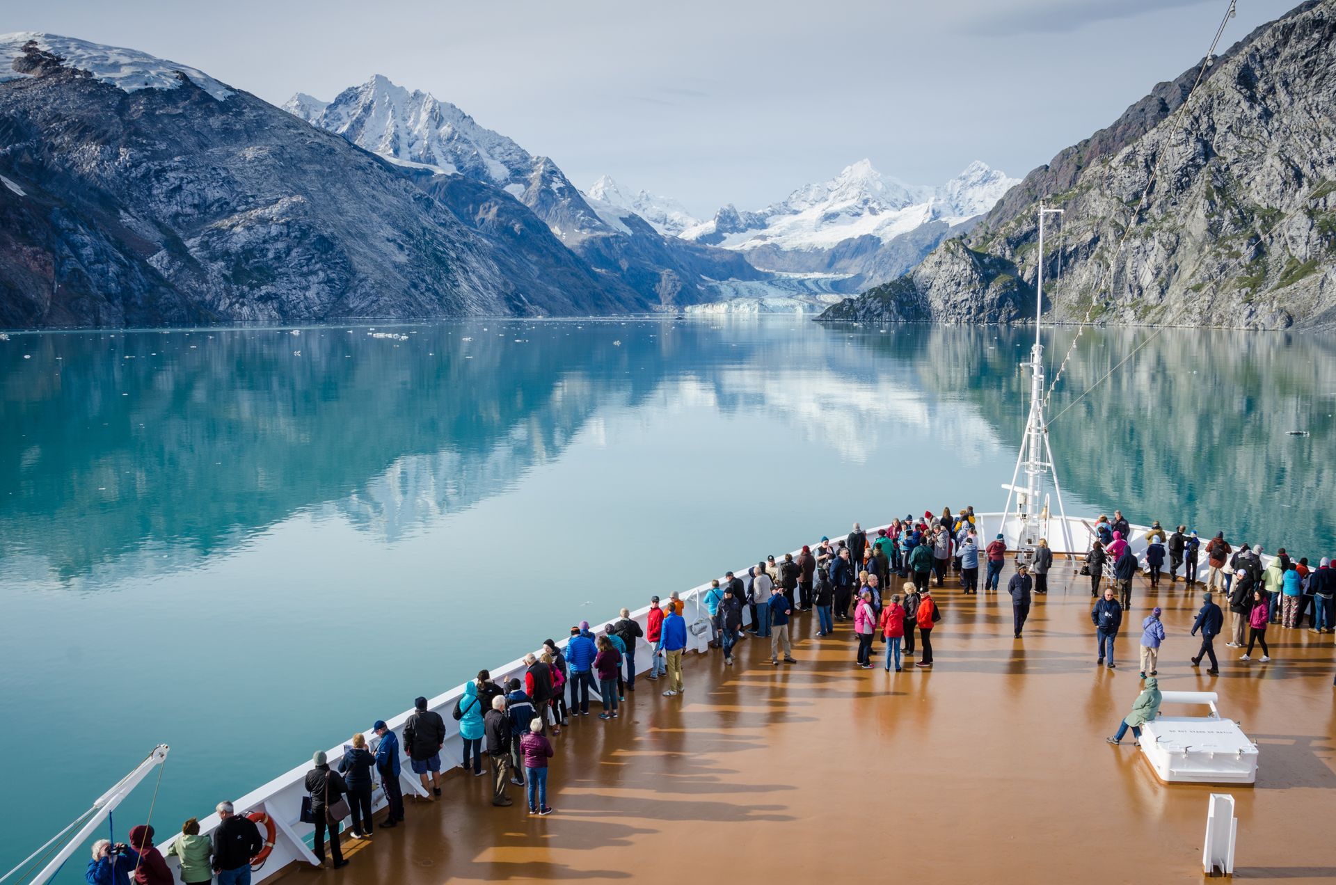 A large group of people are standing on the deck of a cruise ship.