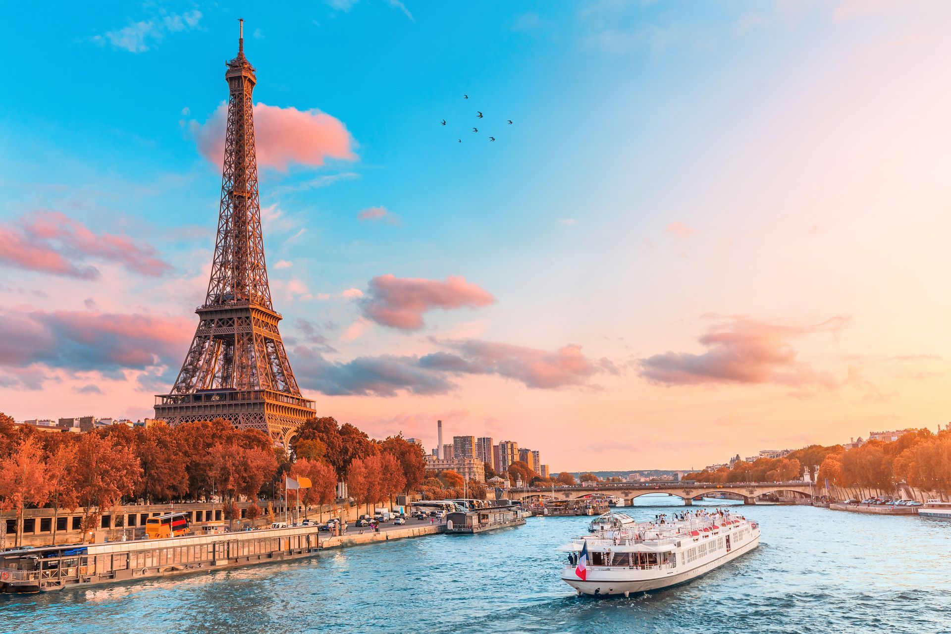 A boat is floating on a river in front of the eiffel tower in paris.