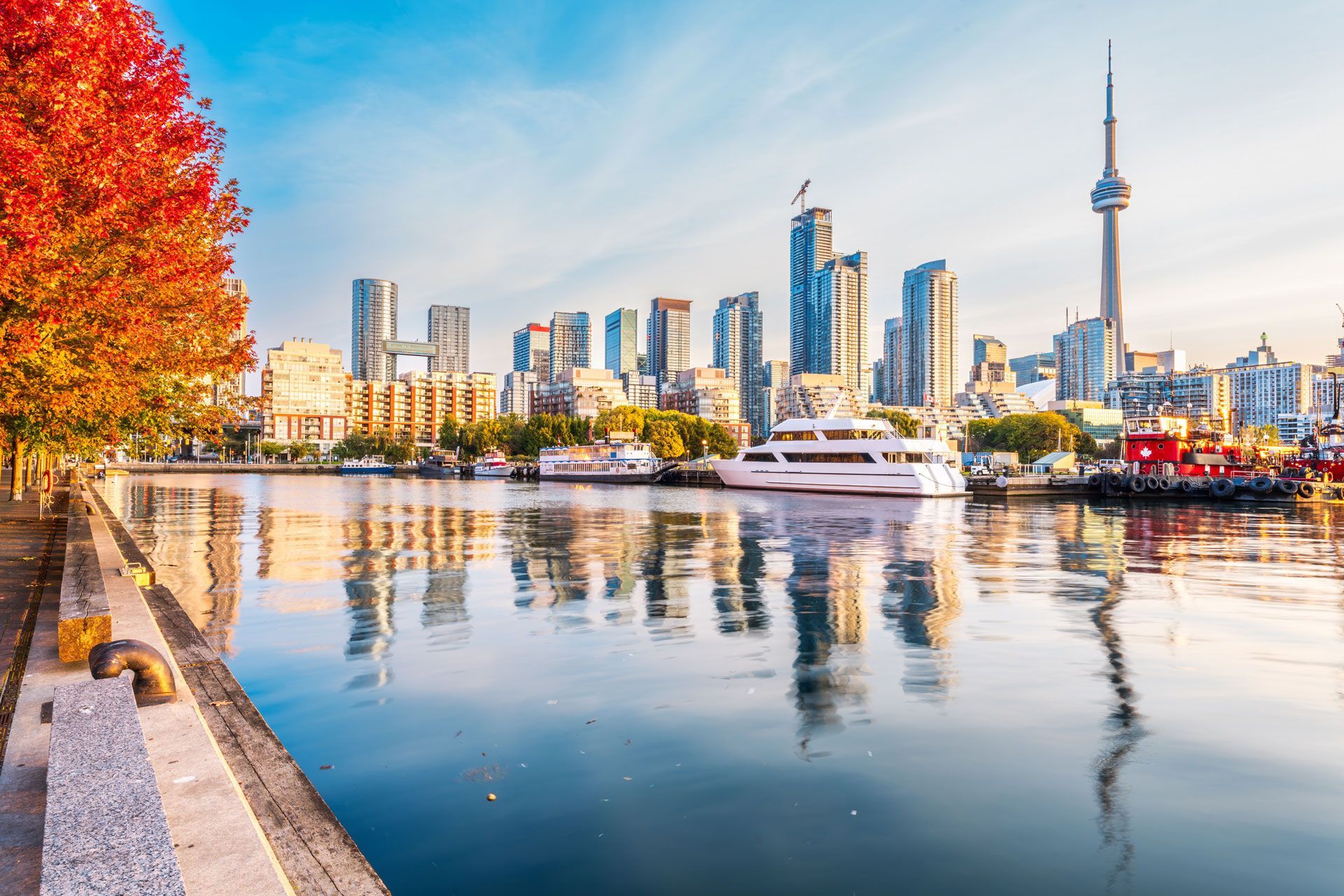 A boat is docked in the water in front of a city skyline.