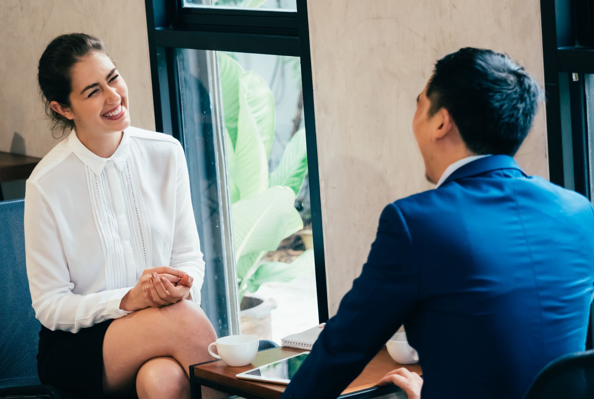 A man and a woman are sitting at a table having a conversation.
