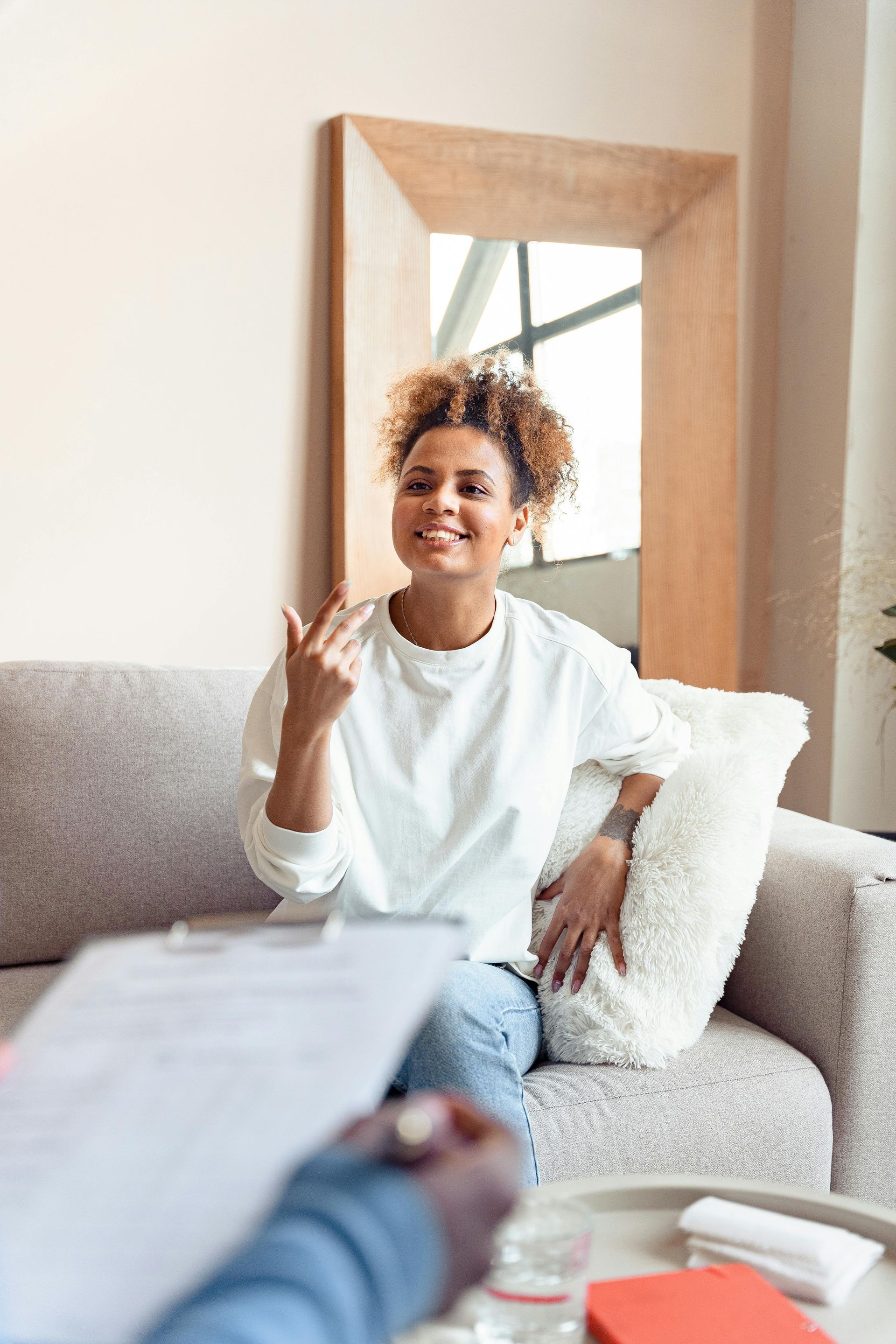A woman is sitting on a couch talking to a man.