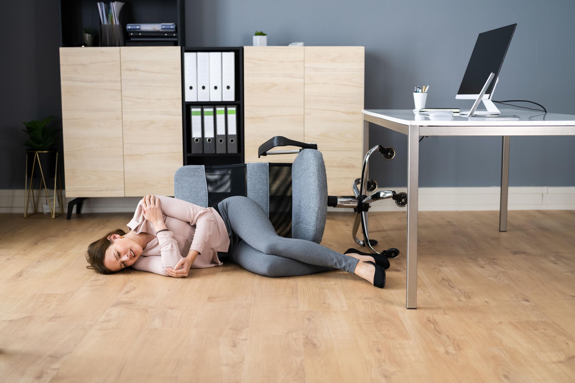 A woman is laying on the floor in an office.