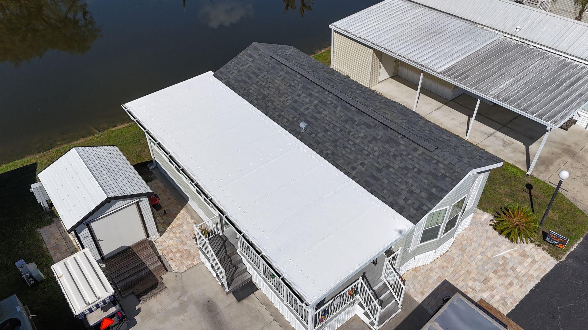 An aerial view of a mobile home with a black roof.