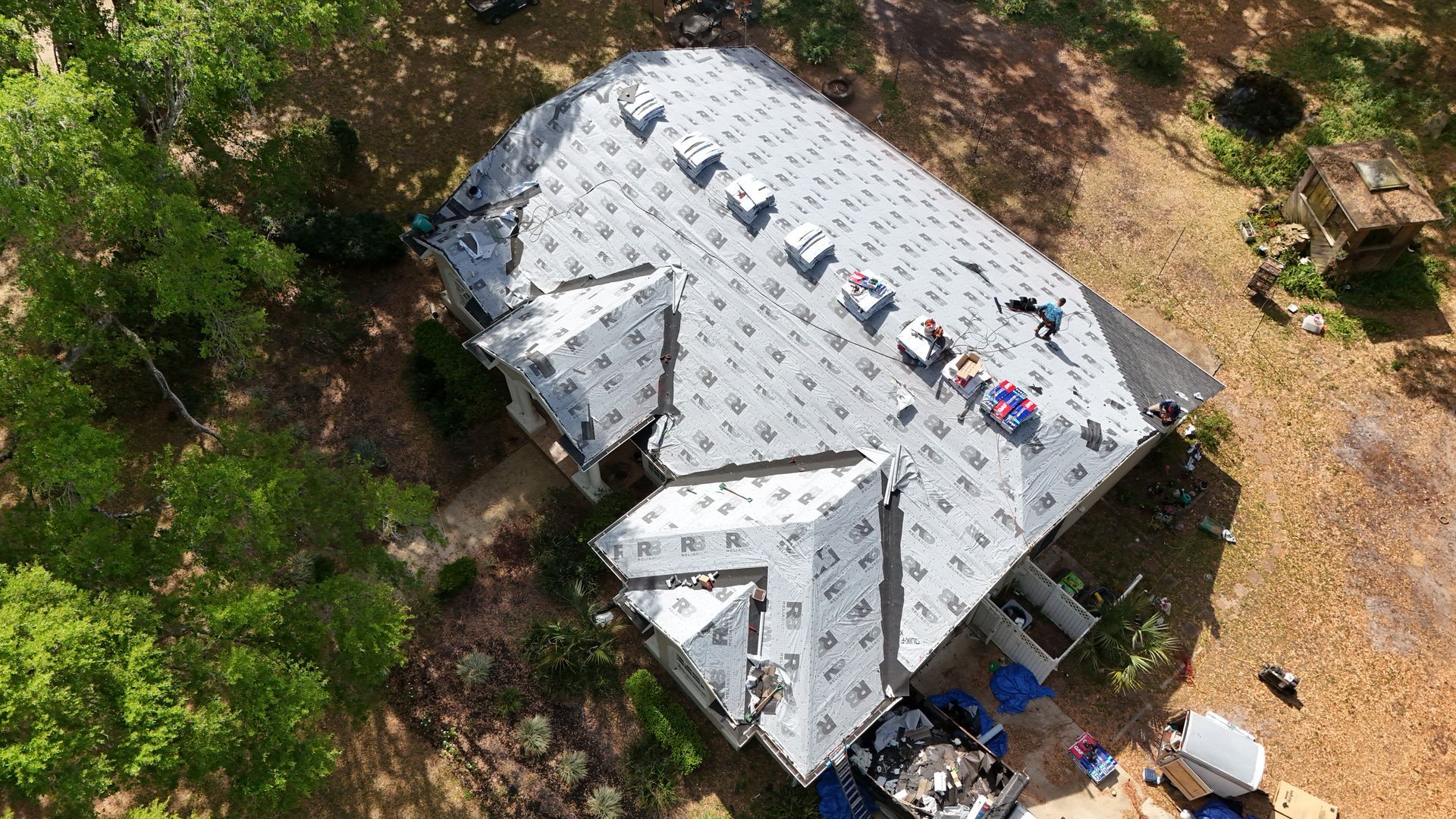 An aerial view of a house with a roof being installed.