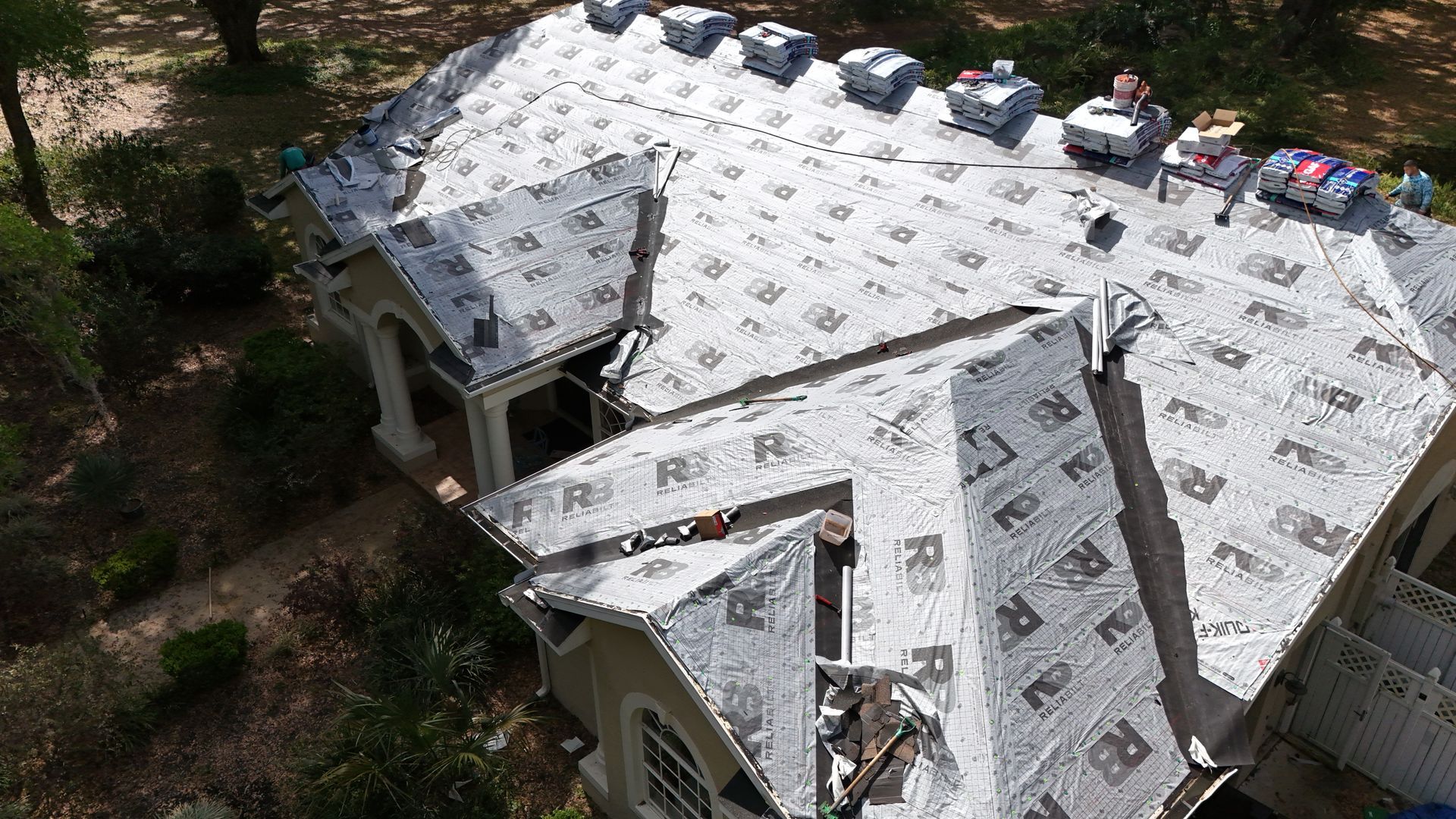 An aerial view of a house with a roof being installed.
