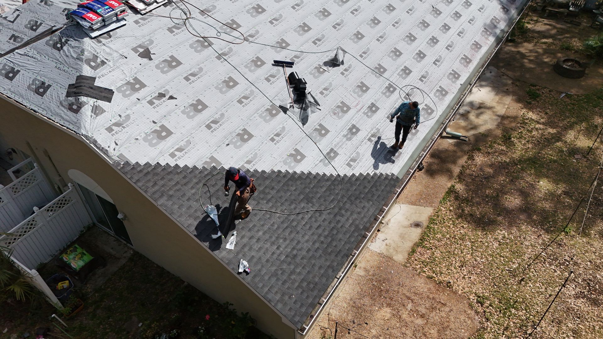 A group of people are working on the roof of a house.