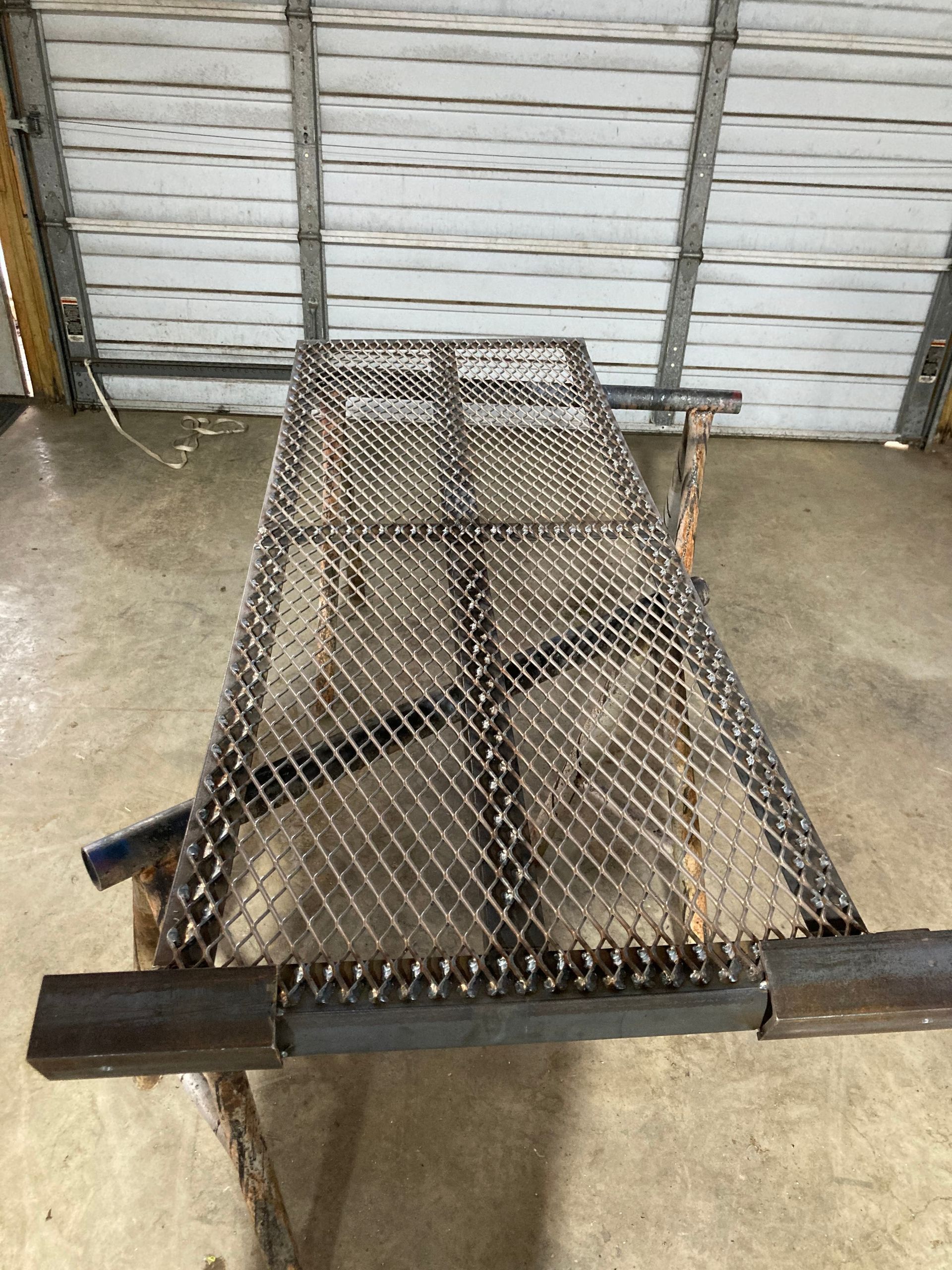 Metal expanded grating platform on a workbench, likely for welding or fabrication.