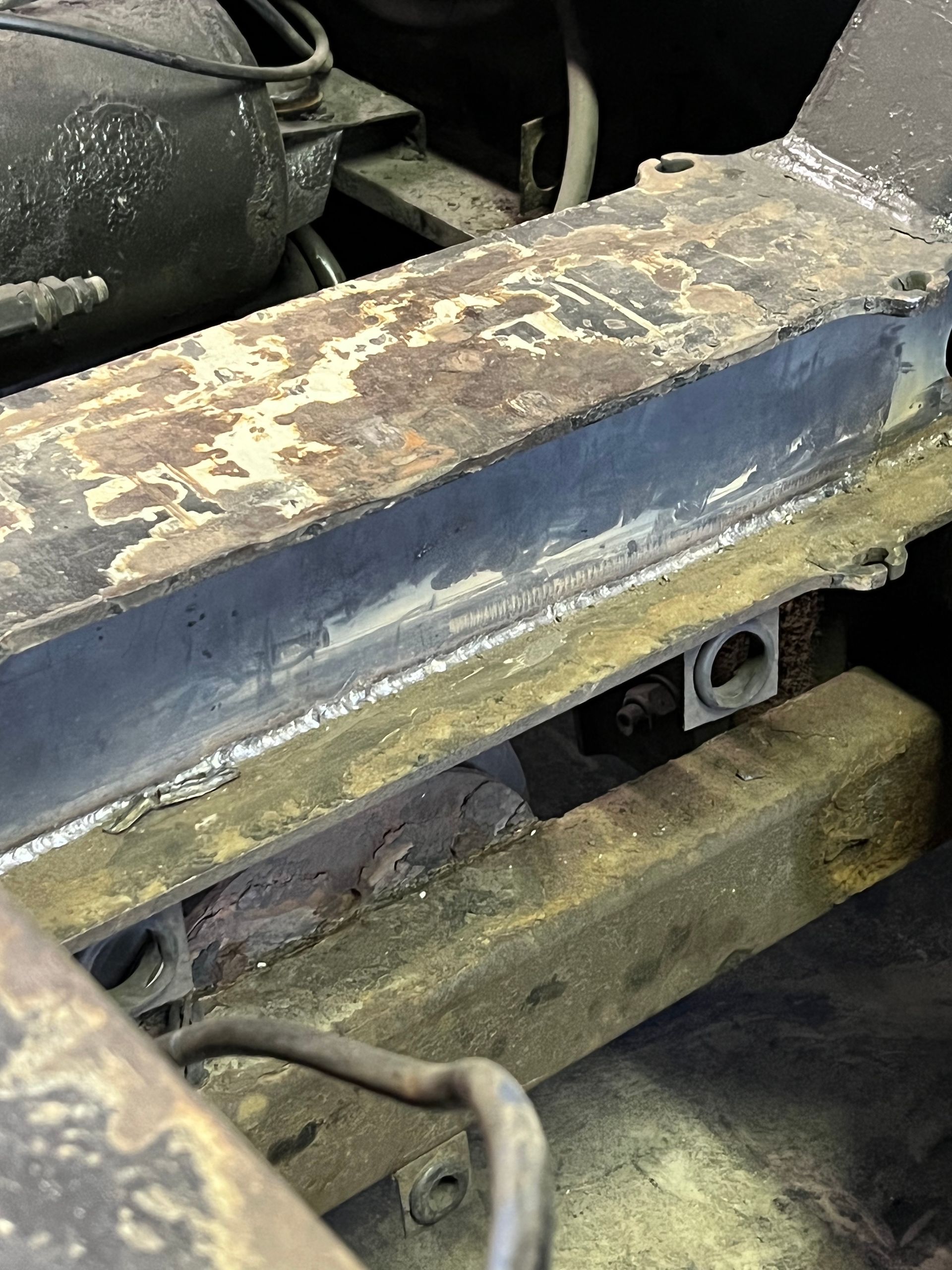 Welder in gloves, welding metal plate in workshop, sparks flying.