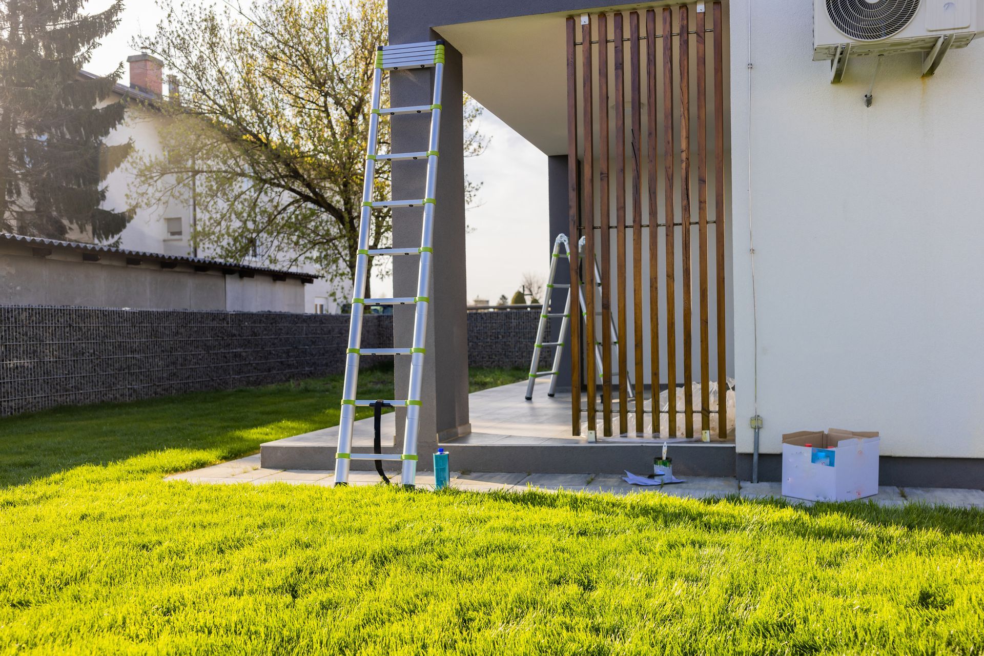 Paint equipment and ladder outside apartment during sunny day