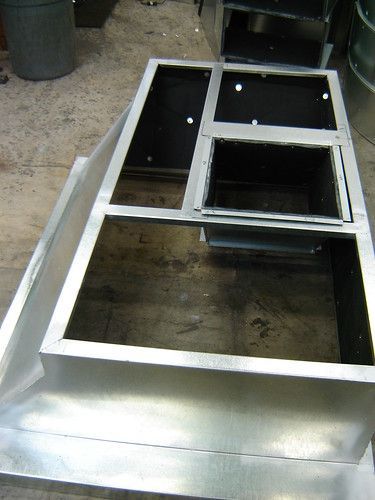 A metal box is sitting on top of a wooden table.
