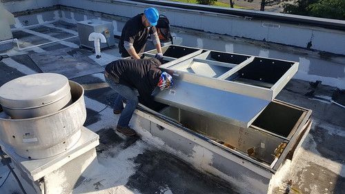 Two men are working on the roof of a building.