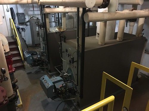 A room with a lot of pipes and stairs in it.