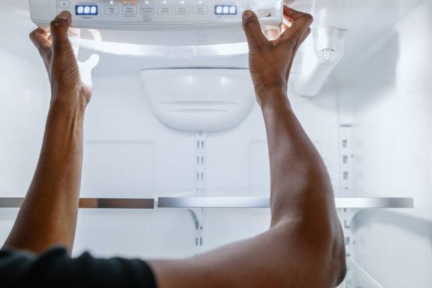 Woman testing functionality of refrigerator's user interface control board.
