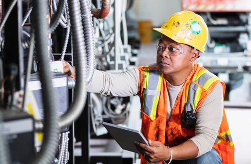 Worker inspecting commercial refrigeration equipment. Worker inspecting commercial refrigeration equipment.
