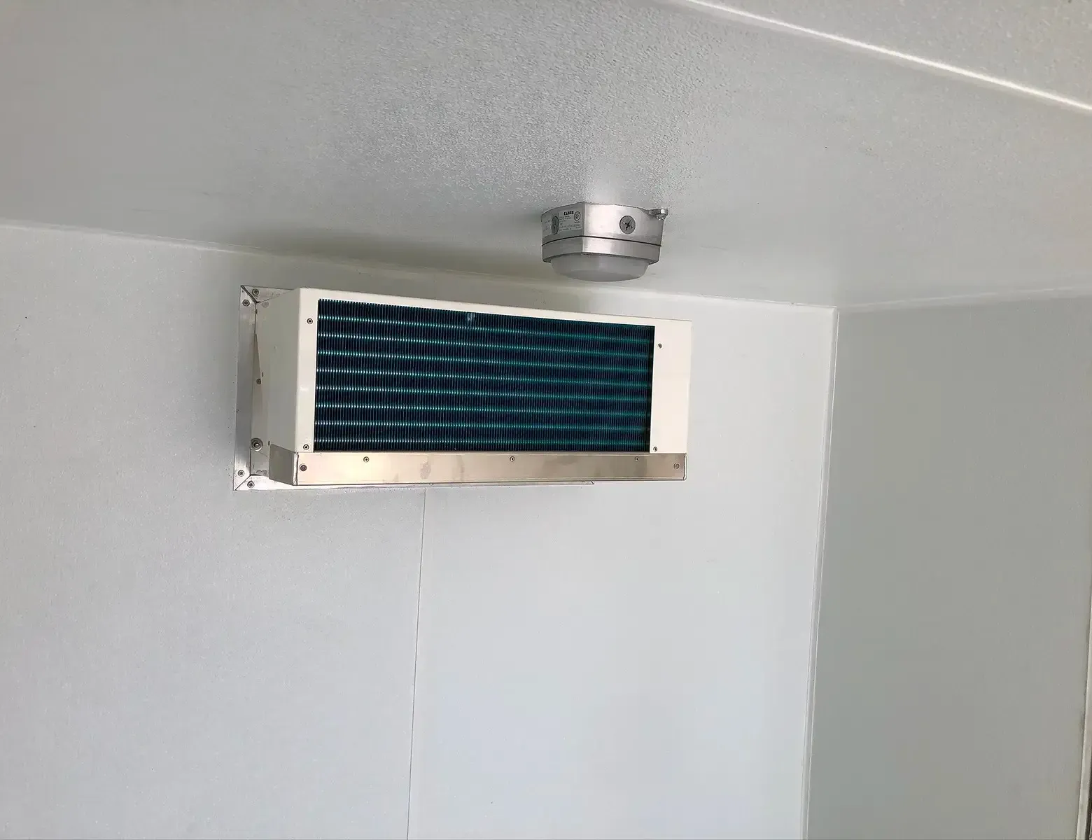 A room with a ceiling fan and a smoke detector on it.