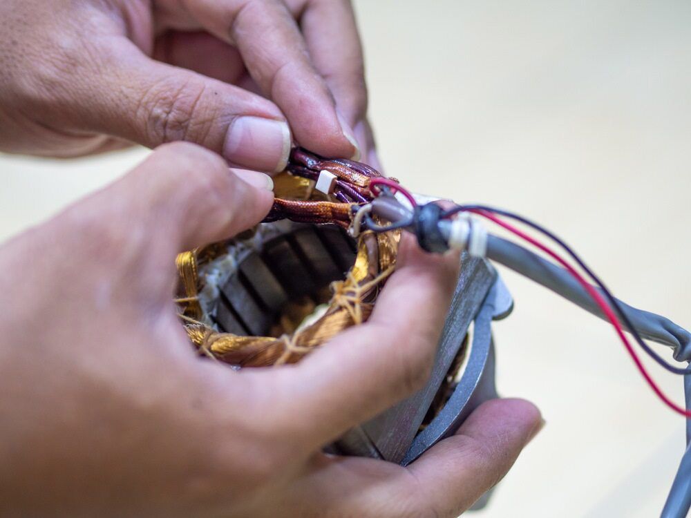 A Person Is Holding A Piece Of Electronic Equipment In Their Hands — EESI Electrical Contractors In Lismore, NSW