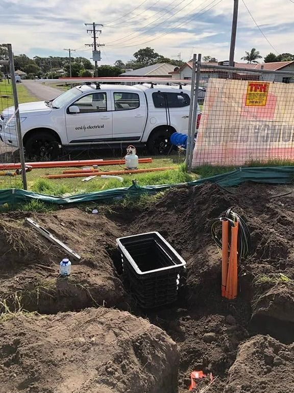 A Man is Working On A Data Switchboard — EESI Electrical Contractors In Alstonville, NSW