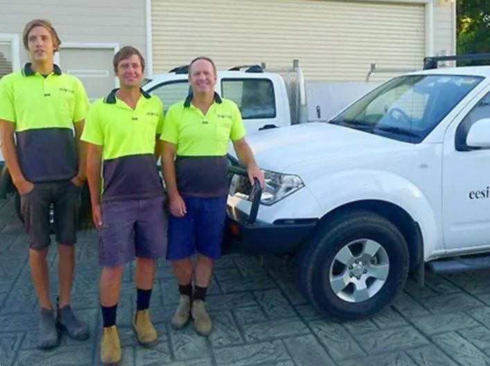 A Man Is Working On A Machine In A Dark Room — EESI Electrical Contractors In Alstonville, NSW