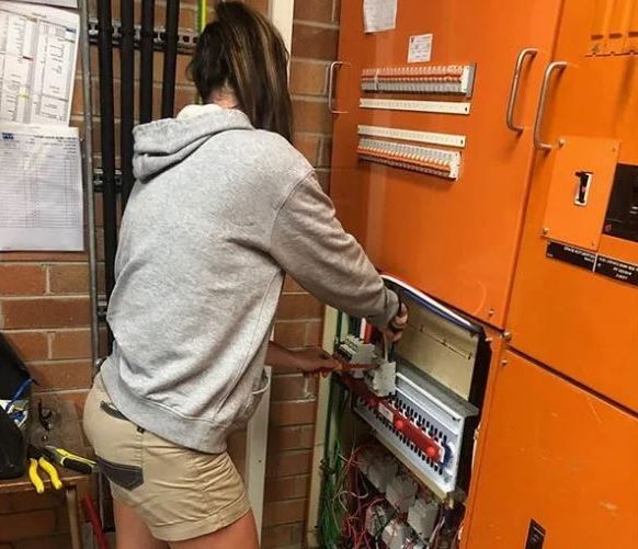 An Electrician Is Working On An Electrical Panel With A Multimeter — EESI Electrical Contractors In Alstonville, NSW