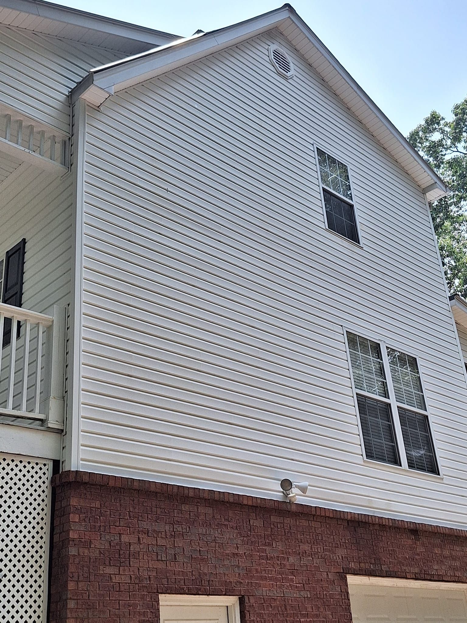 A white house with black windows and a balcony