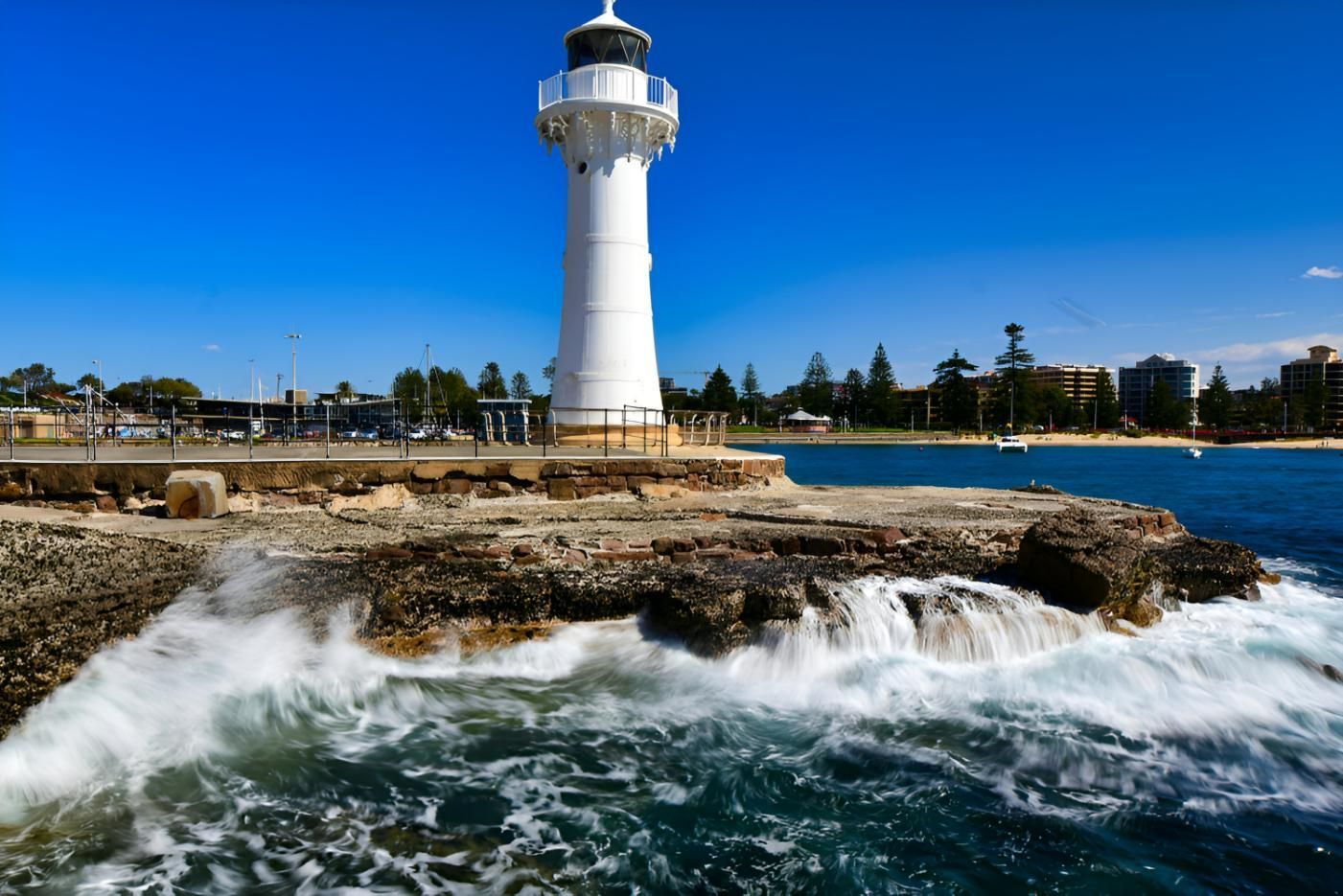 White Lighthouse On Rocky Shore With Waves And Blue Ocean — JSF Interiors Goulburn in Wollongong, NSW