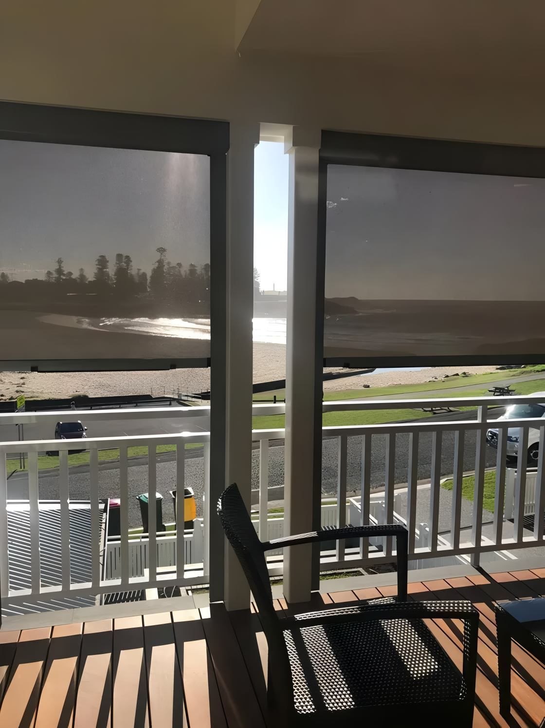 Balcony Overlooking Beach With Roll-Down Blinds And Chair — JSF Interiors Goulburn in Goulburn, NSW