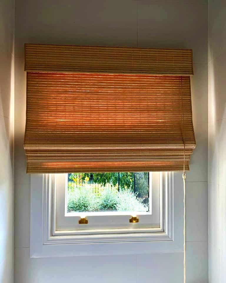 Tan Woven Roman Shade Over White Window — JSF Interiors Goulburn in Gerringong, NSW