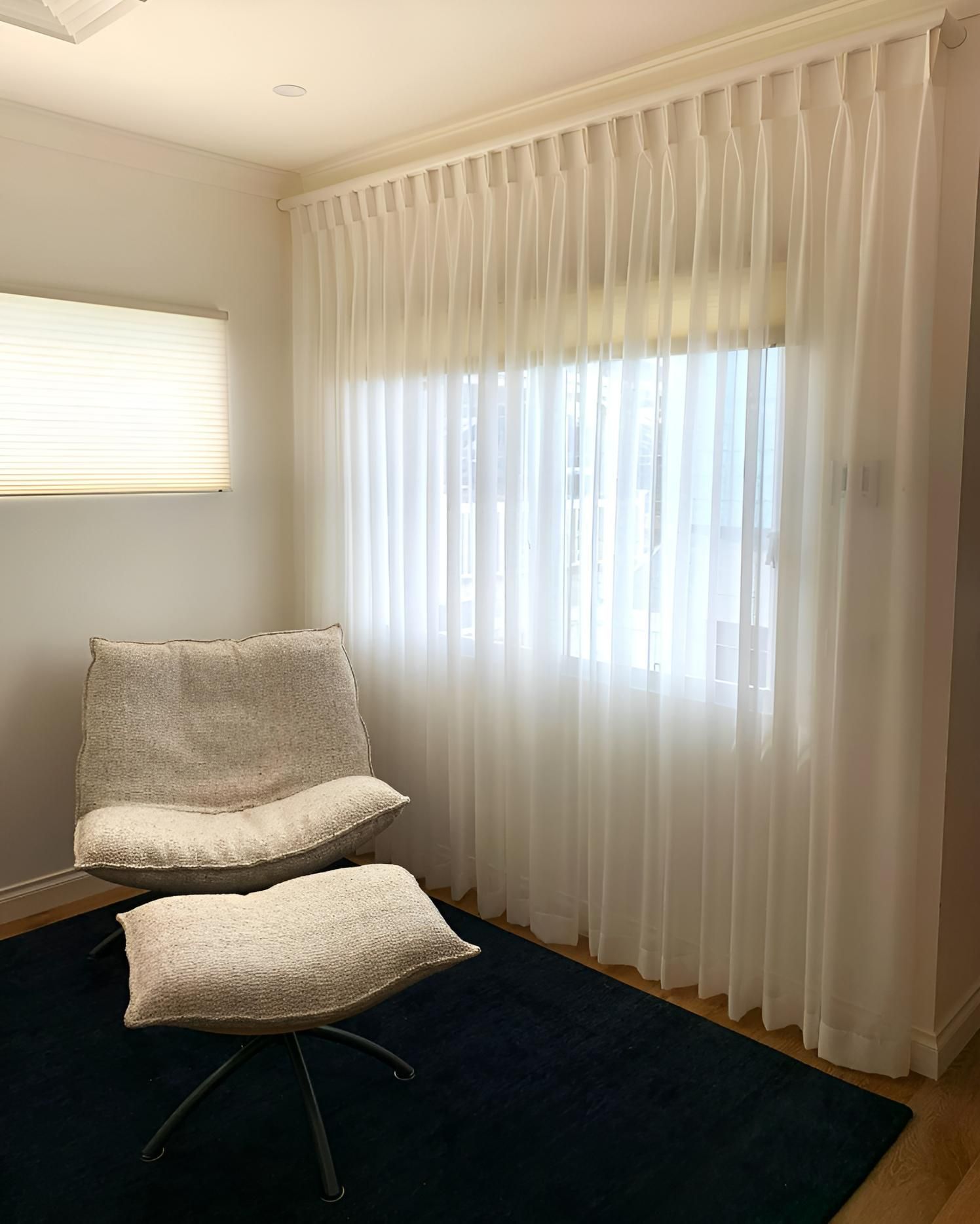 Cozy Reading Nook With White Chair, Ottoman, Sheer Curtains, And Navy Rug — JSF Interiors Goulburn In Kiama, NSW