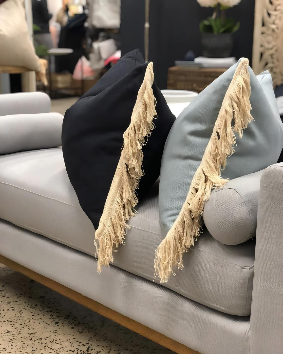 Two Fringed Throw Pillows On Gray Sofa — JSF Interiors Goulburn in Goulburn, NSW